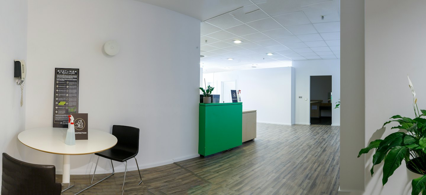 Sala de espera de oficina moderna con mesa redonda y sillas.